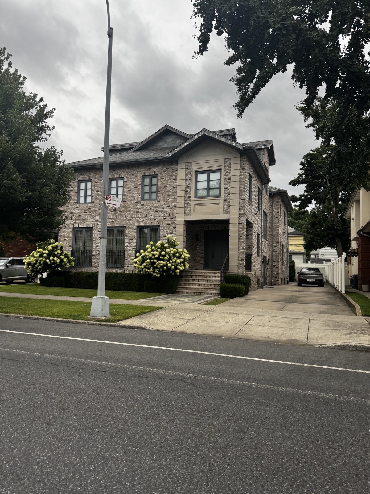 Traditional brick and stone two-story residential exterior with landscaped front yard